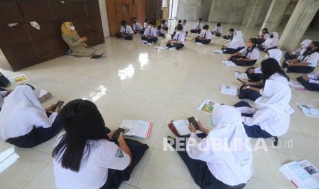 Siswa mengikuti pelajaran Bahasa Indonesia saat pelaksanaan Pembelajaran Tatap Muka (PTM) 100 persen hari pertama di SMP Negeri 1 Kota Kediri, Jawa Timur, Senin (10/1/2022). Pemerintah Kota Kediri mulai melaksanakan PTM 100 persen untuk siswa kelas VI SD dan siswa SMP.