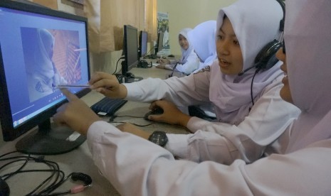 Siswa mengikuti pelajaran praktikum di laboratorium multimedia SMKN 1 Tulungagung, Tulungagung, Jawa Timur, Senin (24/7). Sebanyak enam lembaga yang terdiri dari tiga SMA dan tiga SMK di daerah itu mulai menguji coba pelaksanaan pola pembelajaran lima hari sekolah.