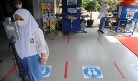 Siswa mengukur suhu tubuh sebelum mengikuti Pembelajaran Tatap Muka Terbatas (PTMT) di SMAN 1 Kota Bogor, Jawa Barat, Senin (4/10/2021). Pemerintah Kota Bogor melakukan PTMT tahap pertama yang diikuti 200 sekolah mulai dari SMP, SMA, SMK, Madrasah dan SLB di Kota Bogor yang telah dinyatakan lolos asesmen, verifikasi faktual dan penerapan protokol kesehatan ketat di sekolah. 