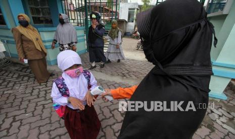 Siswa Aceh Mulai Belajar Tatap Muka. Siswa menjalani pemeriksaan suhu tubuh saat akan memasuki ruang kelas untuk mengikuti belajar tatap muka pertama di SDN-1 Lhokseumawe, Aceh, Senin (9/11/2020). Berdasarkan surat pernyataan wali murid yang mengizinkan putra/putrinya untuk sekolah, Pemkot setempat membuka ujicoba sekolah tatap muka pertama untuk jenjang SD, SMP, SMA dengan jadwal sekolah satu kali dalam seminggu dan jumlah siswa terbatas yakni 15 siswa serta wajib mematuhi protokol Kesehatan.