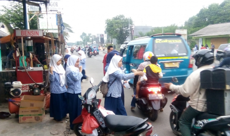 Siswa MTsN 1 Bogor merayakan kelulusan sekolah dengan cara yang unik, yakni dengan membagi-bagikan takjil kepada pengguna jalan di sekitar sekolah mereka di Lebak Wangi, Bogor.