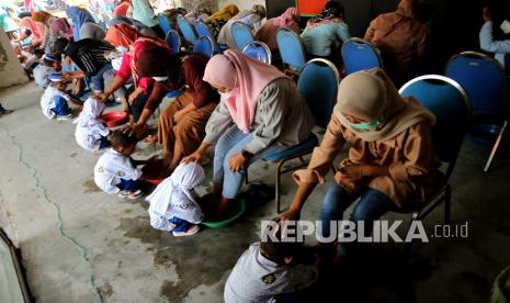 Siswa Pendidikan Anak Usia Dini (PAUD) membasuh kaki ibunya dalam rangka memperingati Hari Ibu di wisata edukasi Ngusikan, Kabupaten Jombang, Jawa Timur, Rabu (22/12/2021). Kegiatan membasuh kaki ibu itu guna mendidik akhlak anak sejak dini agar bisa menghormati serta menghargai ibu.