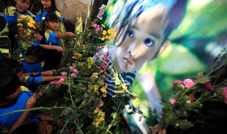 Siswa SD meletakkan bunga saat mengikuti acara doa bersama bertajuk RIP Angeline di Nusukan, Banjarsari, Solo, Jawa Tengah. 