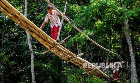 Siswa SD melintasI jembatan bambu yang rusak di Kampung Cigedang, Desa Leuwiipuh, Lebak, Banten, Rabu (30/10/2019).