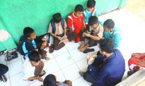 Siswa SD menggunakan Quarter untuk belajar IPA.