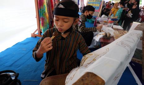 Siswa SD Negeri Sondakan menampilkan proses pembuatan batik tulis saat perayaan projek profil pelajar pancasila di sekolah setempat, Solo, Jawa Tengah, Kamis (16/6/2022). Kegiatan tersebut digelar sebagai wujud apresiasi terhadap karya seni siswa sekaligus mengangkat produk lokal Kota Solo dengan unsur batik. 