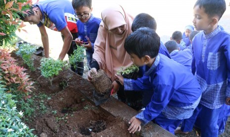 Siswa SD Quran Ar Risalah belajar menanam pohon.