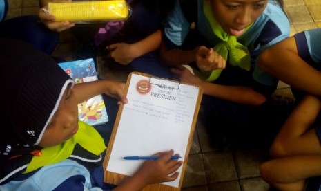 Siswa SD sedang menulis surat untuk Presiden Joko Widodo.