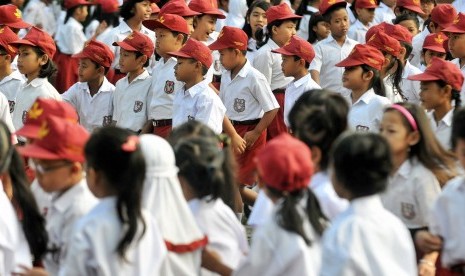 Siswa sekolah dasar berjalan menuju ruang kelas mereka saat hari pertama masuk sekolah pada tahun ajaran baru. 