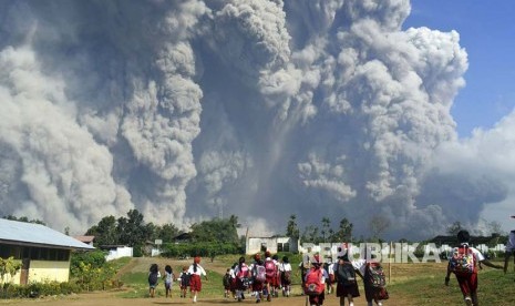 Siswa sekolah dasar menonton letusan gunung Sinabung yang memuntahkan material vulkanik di Karo, Sumatera Utara.