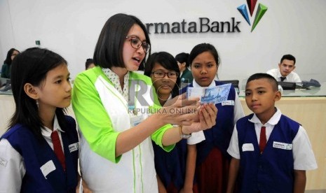 Siswa Sekolah Dasar (SD) mengikuti progrm belajar sambil bermain untuk meningkatkan literasi keuangan dan perbankan di Bank Permata, Jakarta, Kamis (30/7). 