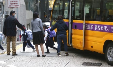 Siswa sekolah dasar turun dari bus sekolah di Hong Kong, Rabu (20/11). Sekolah di Hong Kong dibuka kembali setelah ditutup beberapa hari akibat protes.