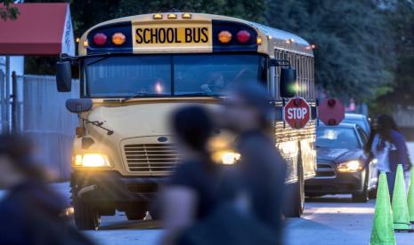 Siswa sekolah menengah berjalan di samping bus sekolah pada hari pertama sekolah di American Senior High School di Hialeah, Florida, AS, 17 Agustus 2023. Amerika Serikat akan mengganti ribuan bus sekolah berbahan bakar gas yang sudah tua, dengan kendaraan yang lebih ramah lingkungan terutama listrik.