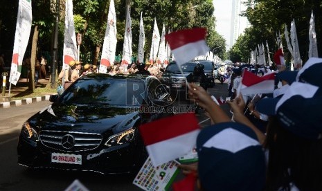 Siswa Sekolah Menengah Pertama menyambut kedatangan Delegasi Negara Asia Afrika dengan bendera Indonesia saat KTT Asia Afrika yang berlangsung di Jakarta Convention Centre, Jakarta, Rabu (22/4). (Republika/Raisan Al Farisi)