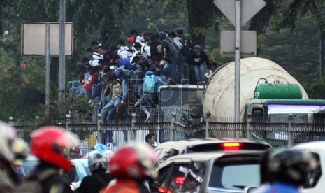  Siswa Sekolah Menengah tingkat atas ditangkap polisi saat menaiki atap bis dalam kota di Jalan Gunung Sahari, Jakarta, Jumat (18/10).     (Republika/ Tahta Aidilla)