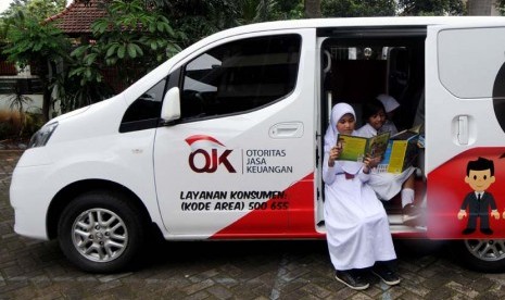 Siswa-siswa di Sekolah Dasar (SD) Kalibata V Pagi membaca buku yang tersedia dalam mobil edukasi keuangan atau yang disebut SIMOLEK 