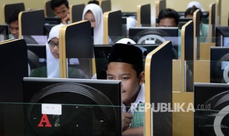 Siswa-siswi MTSN 3 Jakarta, mengerjakan soal ujian mata pelajaran bahasa Indonesia saat Ujian Nasional Berbasis Komputer (UNBK), Senin (9/5). 