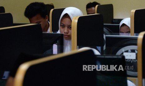 Siswa-siswi MTSN 3 Jakarta, mengerjakan soal ujian mata pelajaran bahasa Indonesia saat Ujian Nasional Berbasis Komputer (UNBK), Senin (9/5). 