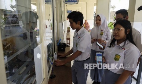 Siswa SMA Batik 1 Solo mengantre untuk menunjukkan transaksi pembayaran non tunai dari Sumbangan Pembinaan Pendidikan (SPP) dengan aplikasi pembayaran digital GoBills di sekolah setempat, Solo, Jawa Tengah, Selasa (18/2/2020).