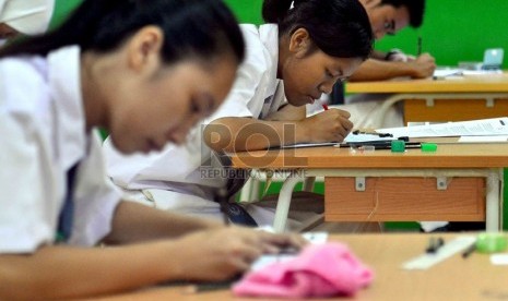  Siswa SMK mengikuti Ujian Nasional di SMK Negeri 8 Jakarta Selatan, Senin (15/4).   (Republika/Agung Supriyanto)