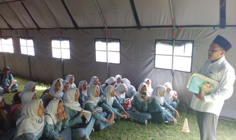 Siswa SMKN 3 Kota Tasikmalaya belajar di tenda, Senin (15/1). Sejumlah ruangan disana mengalami kerusakan lantaran dihantam gempa pada pertengahan Desember lalu.