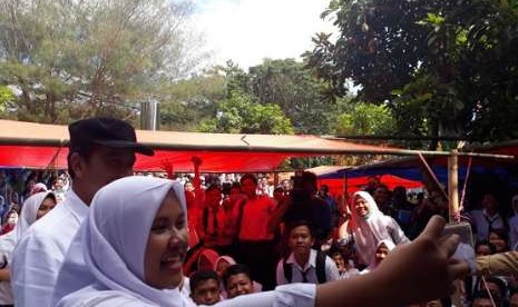 Siswa SMP 6 Mataram tak mau melewatkan kesempatan dan berswafoto dengan Presiden Joko Widodo saat datang meninjau kerusakan di sekolah itu akibat gempa, Senin (3/9)