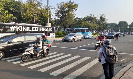 Situasi Jalan Medan Merdeka Barat, Jakarta Pusat saat hari pertama pemberlakuan sistem ganjil genap, Senin (3/8).