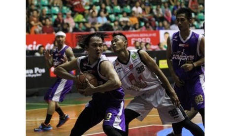 Small forward CLS Knight Rachmad Febri Utomo (pegang bola) berusaha menembus pertahanan Hangtuah Sumsel IM dalam lanjutan NBL Indonesia Seri VI Solo, Kamis (26/2).