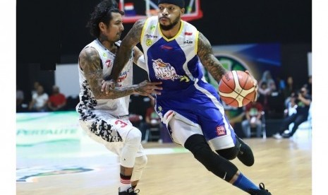 Small Forward Satria Muda Pertamina Jamarr Andre Johnson dijaga point guard Hangtuah Sumsel Kelly Purwanto.