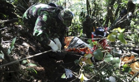 Soldiers remove a body bag containing the remains of victims of the Sukhoi Superjet 100 crash in Mount Salak, West Java.  