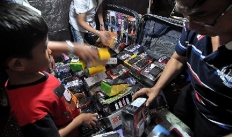 Some potential buyers flock a street vendor sell inexpensive imported cellphones in Jakarta. (illustration)  