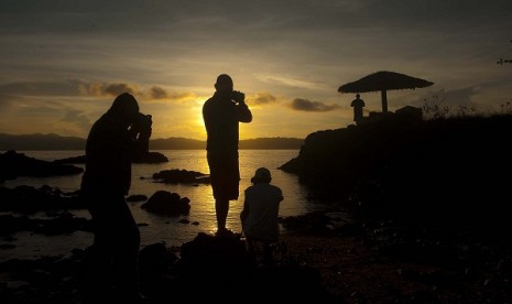 Some tourists capture the sunrise in Desa Tulehu, Ambon. The island offers a number of potentials for tourism and other economic cooperations. (illustration)