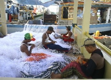 Some traditional fishermen repair fishingnets in Indramayu, West Java. Traditional fishing is among vurnerable sectors hit as oil price rises (illustration).  