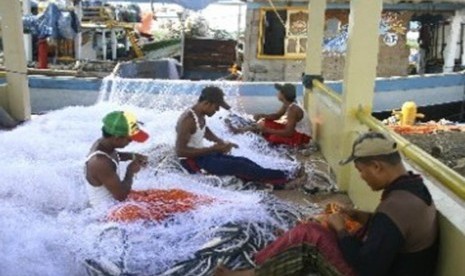 Some traditional fishermen repair fishingnets in Indramayu, West Java. (illustration).  