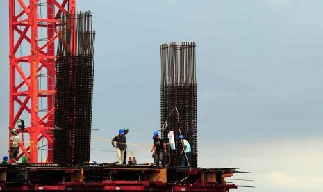 Some workers build a skyscraper in Jakarta. World Bank cut growth projection of Indonesian gross domestic product (GDP) due to moderation of investment growth. (illustration)