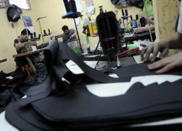 Some workers sew material for bags in a small enterprises in Manggarai, Jakarta. (illustration) 