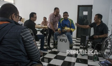 Sosialisasi Pemilu Untuk Disabilitas. Warga penyandang disabilitas mencoba duduk di atas kotak suara untuk mengetahui kekuatan kotak suara tersebut pada acara Sosialisasi dan Pendidikan Bagi Pemilih Disabillitas pada Pemilu 2019 di GOR Pajajaran, Bandung, Jawa Barat, Rabu (27/2/2019). 