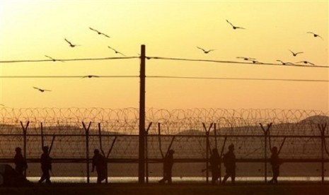 South Korean army soldiers patrol along a barbed-wire fence near the border village of Panmunjom in Paju, South Korea, Tuesday evening, March 26, 2013. 