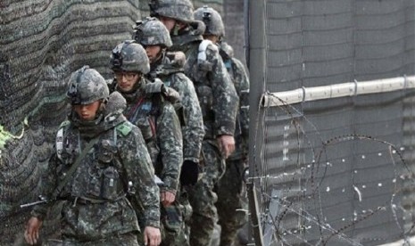 South Korean Army soldiers patrol along a barbed-wire fence near the border village of the Panmunjom, in Paju, South Korea, Saturday, April 13, 2013. 