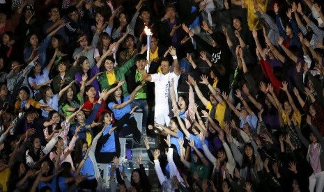 South Korean tennis player Lee Hyung-taik carries the torch during the Opening Ceremony of the 17th Asian Games in Incheon September 19, 2014. 