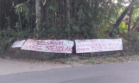   Spanduk bertuliskan penolakan terkait rencana dibangunnya tempat pembuangan sampah sementara terpampang di wilayah Karanggeneng, Umbulharjo, Cangkringan, Sleman, Rabu (26/7/2023).