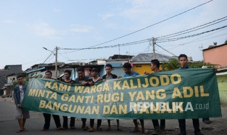 Warga memasang spanduk yang bertuliskan tuntutan ganti rugi atas penertiban permukiman di Kalijodo, Jakarta, Kamis (18/2).