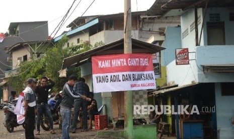 Warga memasang spanduk yang bertuliskan tuntutan ganti rugi atas penertiban permukiman di Kalijodo, Jakarta, Kamis (18/2).