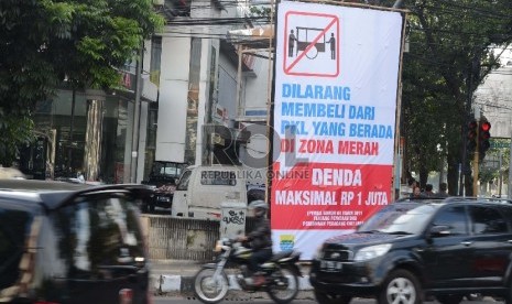 Spanduk himbauan larangan membeli dari pedagang kaki lima (PKL) yang berjualan di zona merah di Jl Medeka, Kota Bandung.