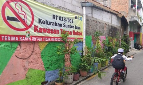 Spanduk kawasan tanpa rokok terpampang di gang menuju RT 13 RW 01 Kelurahan Sunter Jaya, Tanjung Priok, Jakarta Utara, Jumat (15/2).