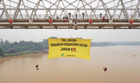 Spanduk raksasa dibentangkan aktivis Greenpeace Indonesia di Jembatan Sungai Kahayan, Palangkaraya, Ahad (22/9).