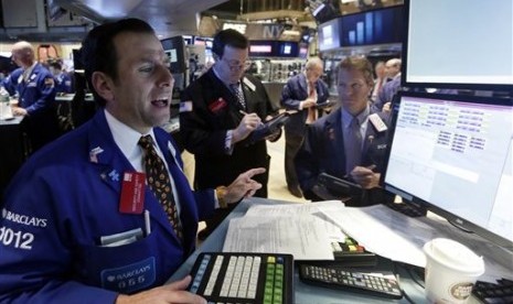 Specialist Michael Pistillo, left, works with traders at his post on the floor of the New York Stock Exchange, Friday, Oct. 31, 2014. 