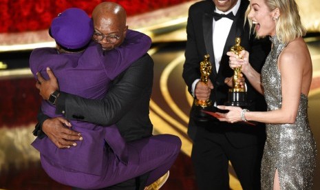 Spike Lee (berbaju ungu) memeluk aktor Samuel L Jackson setelah memenangkan Oscar, Senin (25/2), di Dolby Theatre, Los Angeles.