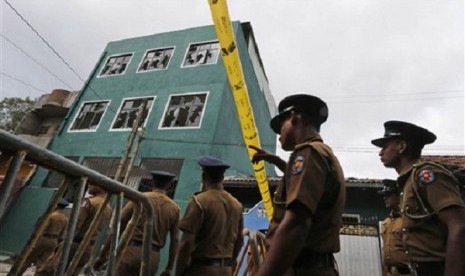 Sri Lankan police officers patrol outside a vandalized mosque in Colombo, Sri Lanka, Sunday, Aug. 11, 2013. 