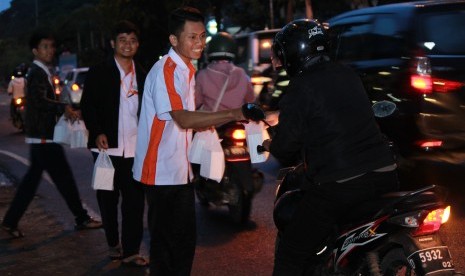 Staf BMH membagikan takjil gratis di Bandung.